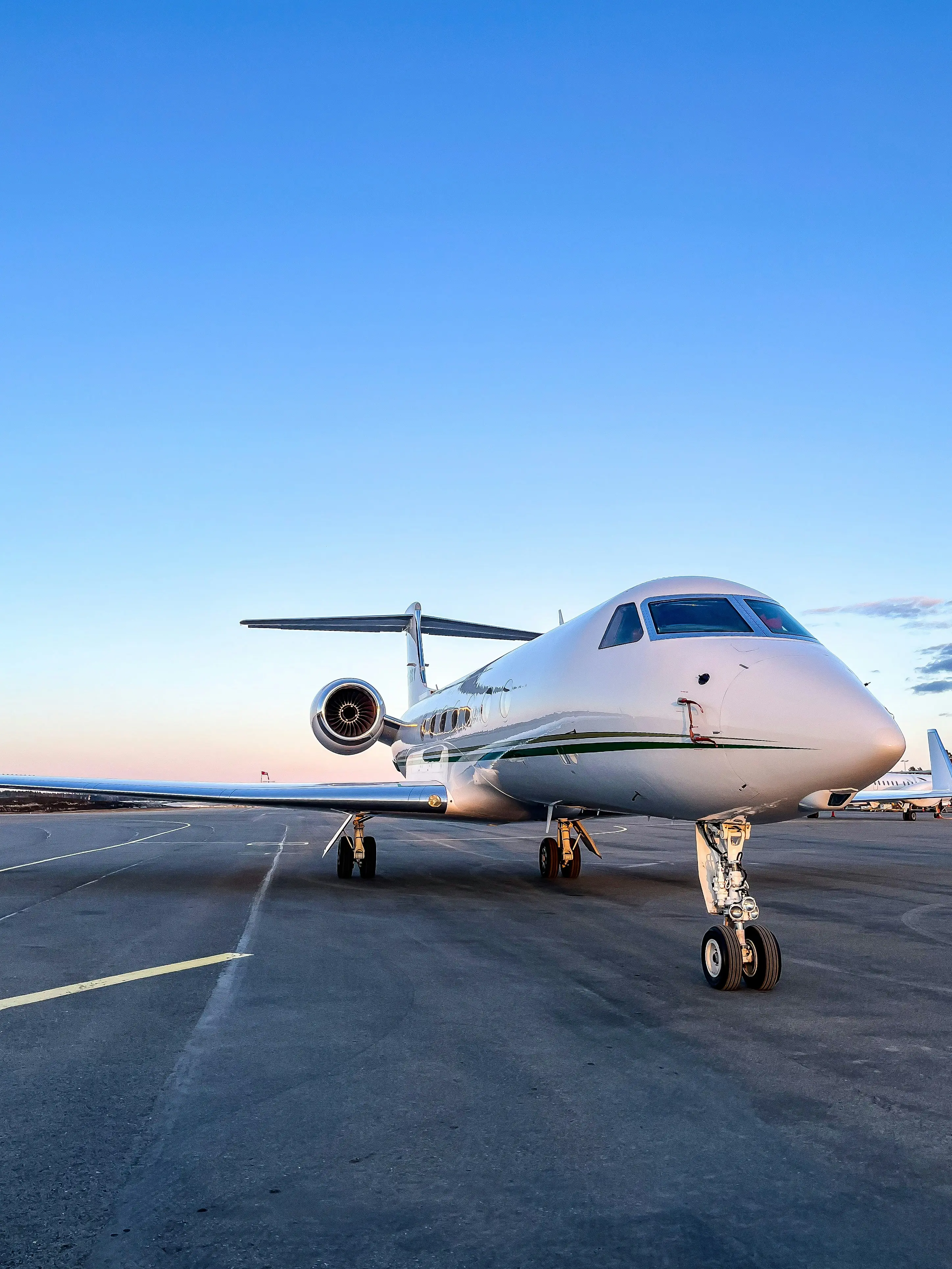 Private jet on sunlit tarmac near city skyline, evoking premium travel, comfort, and exclusivity.